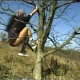 A European woman climbs a tree and takes a shit while hanging in the tree. Over 5 minutes.